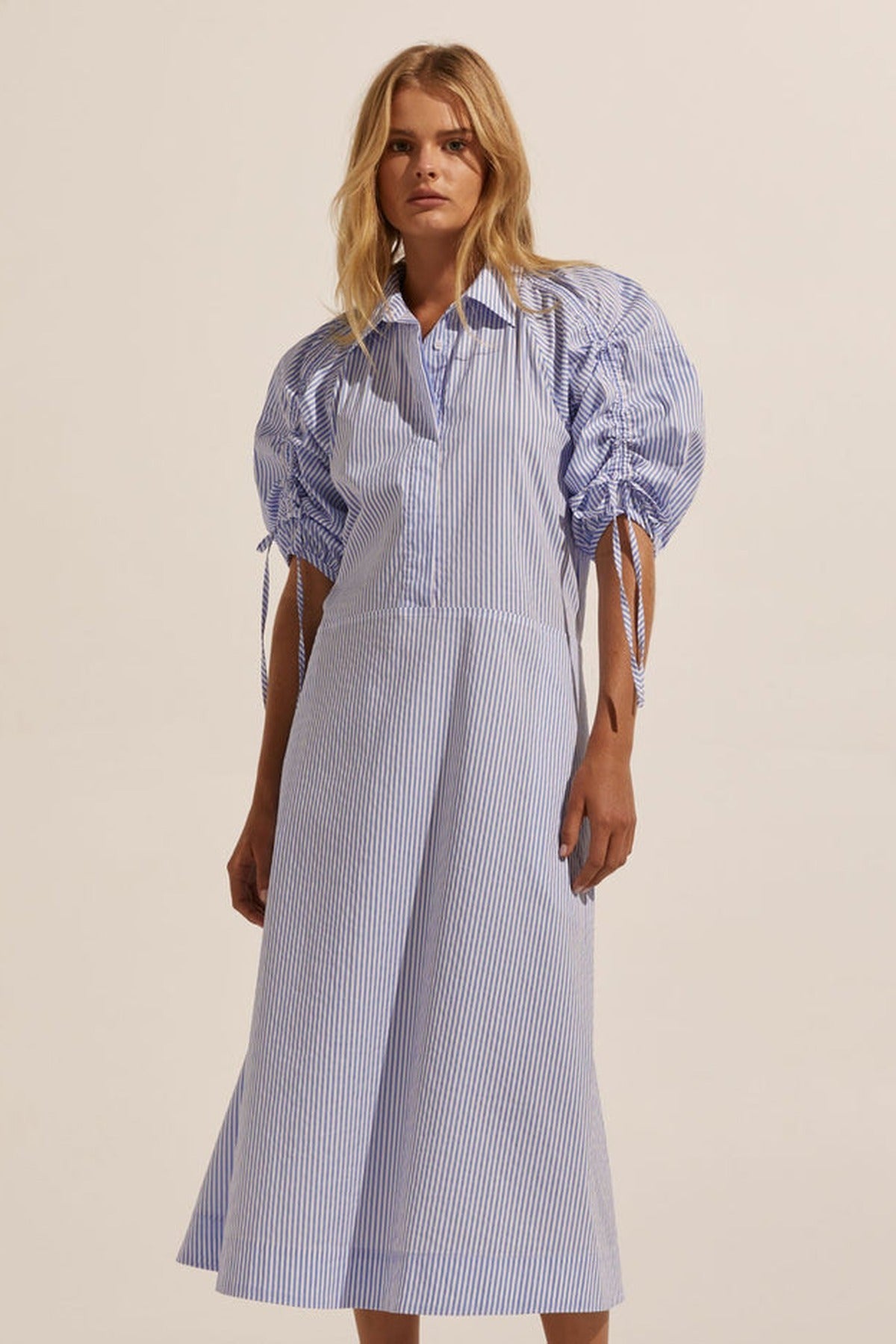 A Zoe Kratzmann dress in lilac cotton with gathered sleeves, photographed against a pale wall