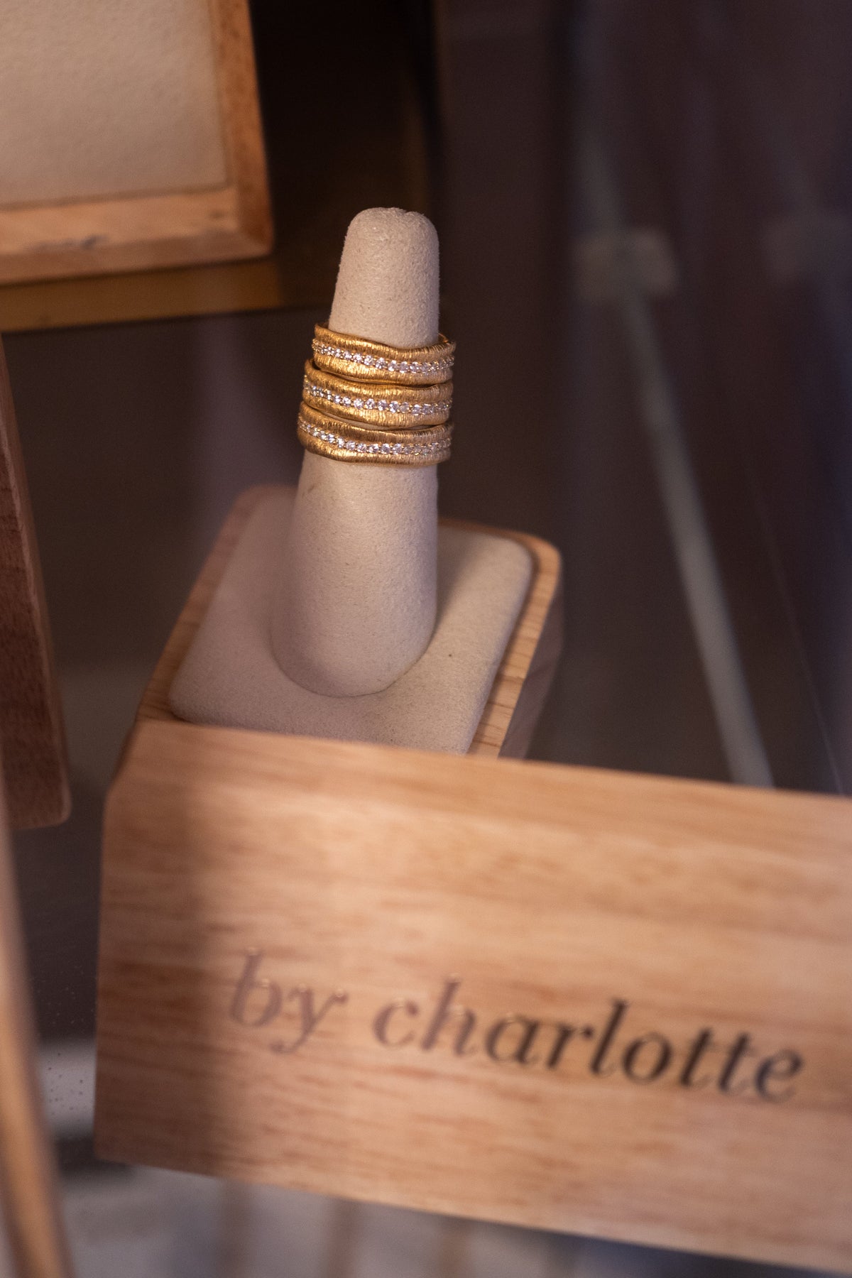 A By Charlotte ring resting on the branded timber block on the jewellery shelf at Amelie & Frank's in Red Hill