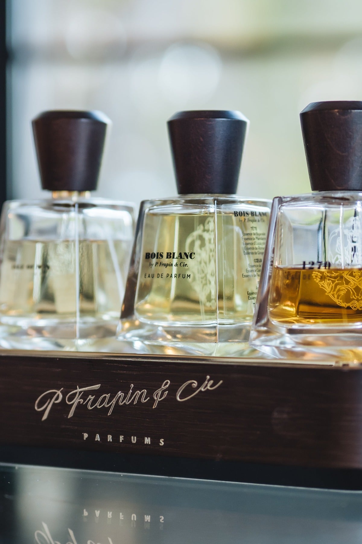 Three P Frapin & Cie bottles on the branded timber stand at Amelie & Frank's in Red Hill