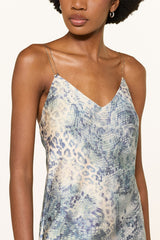 Close view of the V neckline and gold chain straps on the blue animal print slip dress