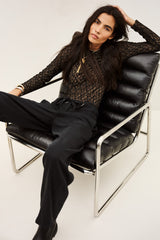 ba&sh Pavana Pants in carbone, worn by model, seated in a lounge chair
