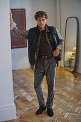 Chocolate quilted lambskin vest worn with grey trousers, full length
