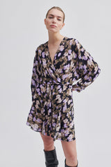 Second Female Cast Printed Dress in black with blurred floral print, worn by model, angled view