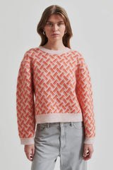 Second Female Kaja Printed Knit in coral and pale pink, worn by model with grey jeans, front view