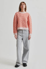 Second Female Kaja Printed Knit in coral and pale pink, worn by model with grey jeans, full length