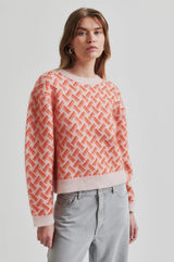 Second Female Kaja Printed Knit in coral and pale pink, worn by model, angled view
