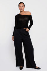 Vaenn Remsen One Shoulder Sheer Knit in black, worn by model with black wide-leg trousers, front view