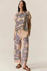 POL Alter Pant in tan with navy swirl print, worn by model with matching top and sandals, front view