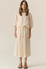 POL Henri Tee in natural, worn by model with a matching drawstring skirt, front view