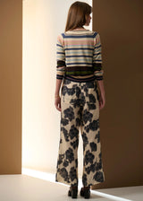 POL Amara Pant in cream with charcoal floral print, on figure with a striped knit, back view