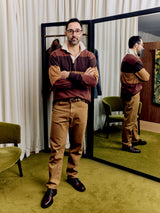 Christian Kimber Rose Street Selvedge Jeans in camel, worn by model in a fitting room with a striped rugby top