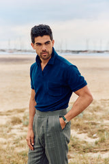 Christian Kimber Coogee Terry Polo in marine, worn by model on a beach with green striped trousers
