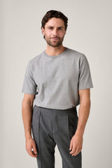 Christian Kimber Apollo T-Shirt in grey, worn by model with grey pleated trousers, front view
