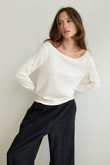 Vaenn Baby Wool Long Sleeve Wide Neck Crew in double cream, worn by model with charcoal trousers, front view
