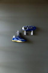 Run Of Skyline Sneaker in blue and yellow, pair on wall hooks, wide view