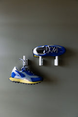 Run Of Skyline Sneaker in blue and yellow, pair on wall hooks, close view