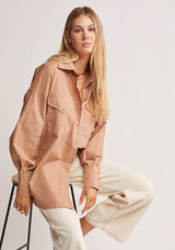 Mos The Label Wanderer Blouse in dusty clay, worn by model seated on a stool