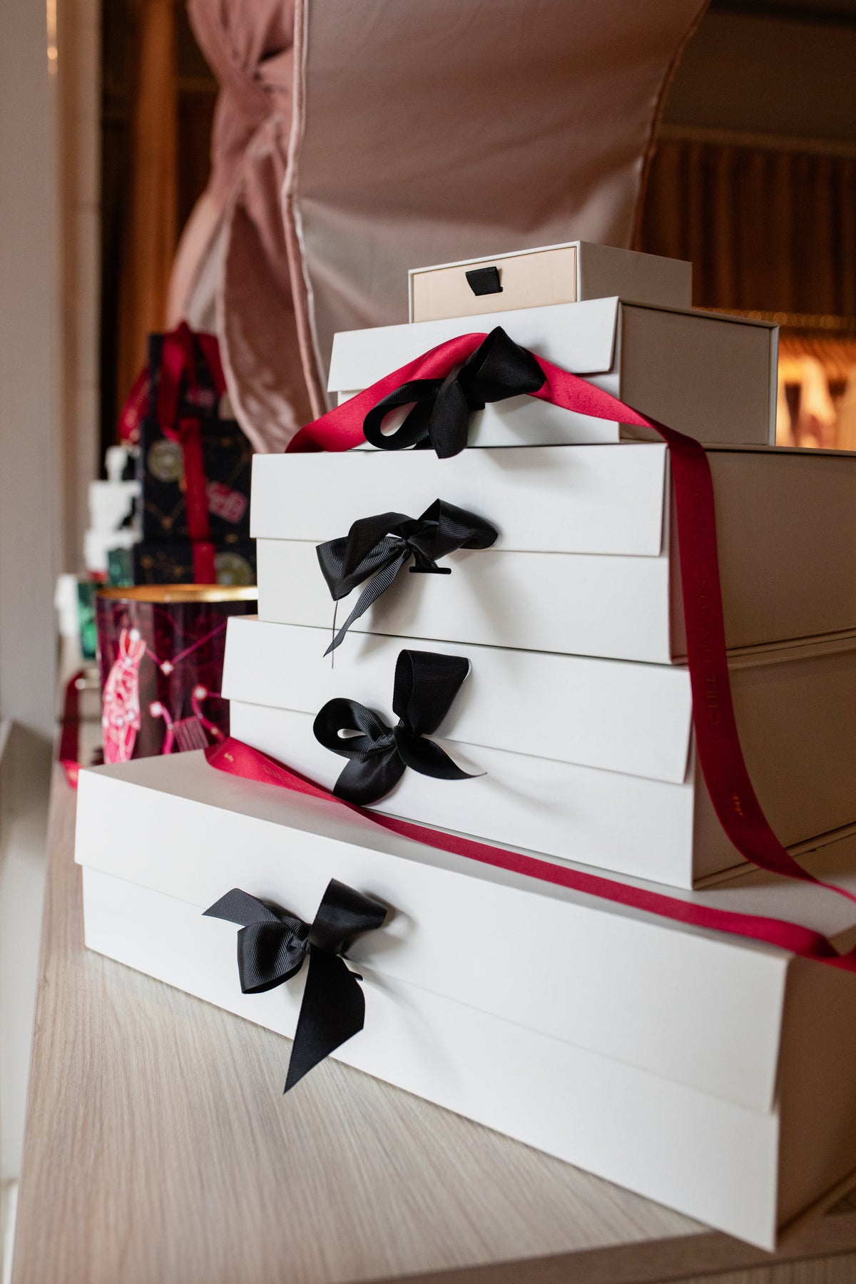 A stack of Amelie & Frank's gift boxes tied with black grosgrain ribbon on the counter in the Red Hill boutique