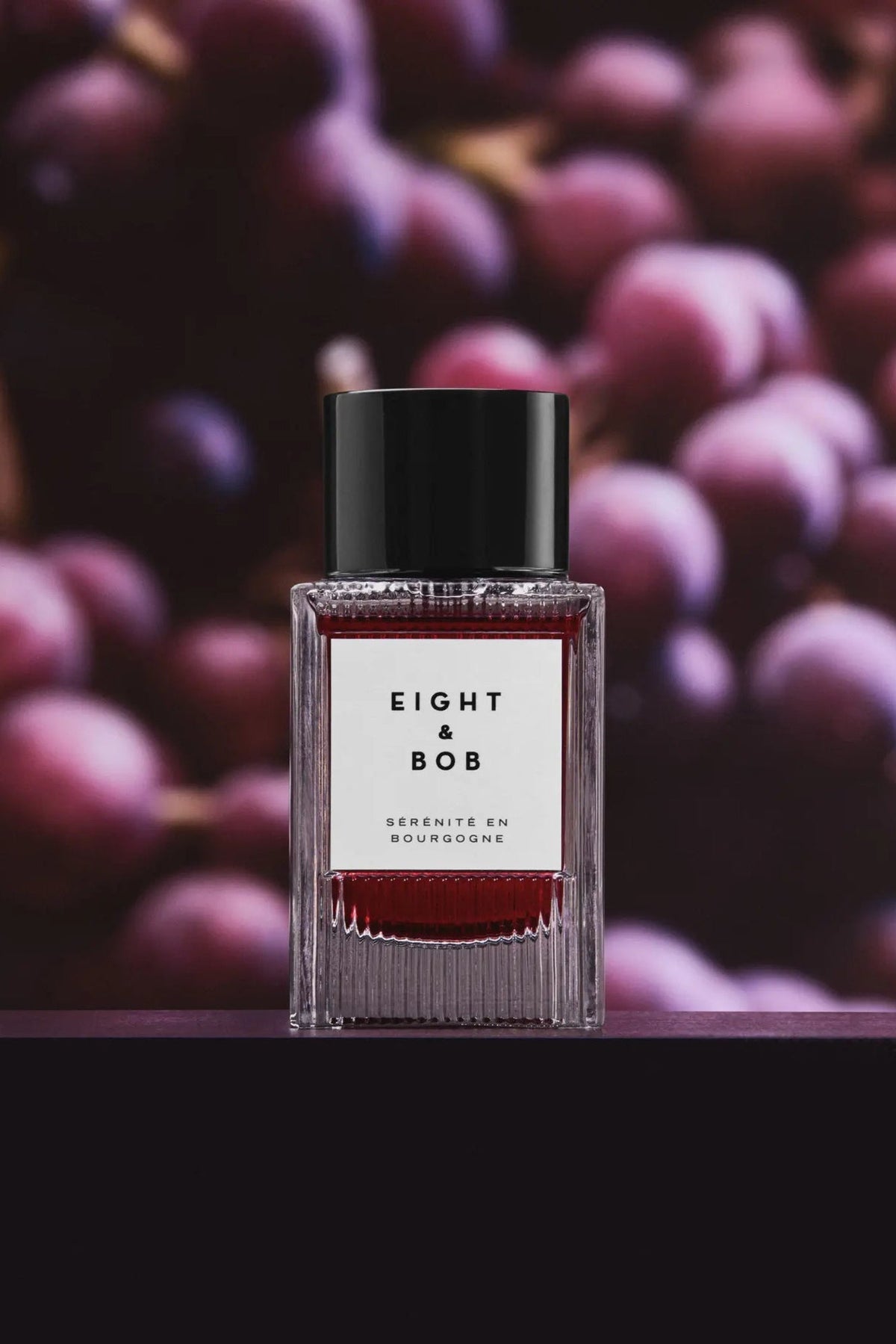Eight & Bob Serenite en Bourgogne in the current square glass flacon, shot against ripe fruit