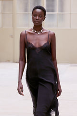 Waist-up view of the black Balma slip worn with a pearl necklace
