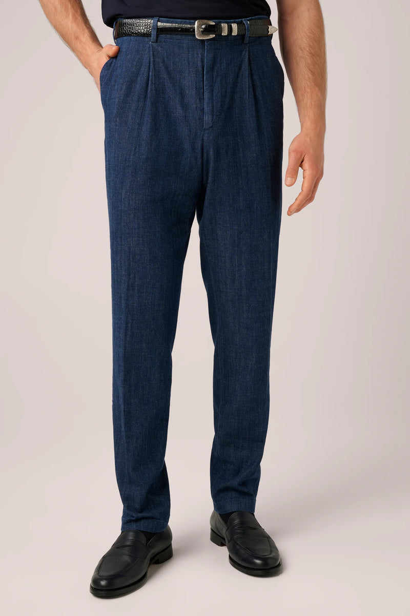 Washed indigo denim chinos with a single front pleat, worn with a woven leather belt and black loafers