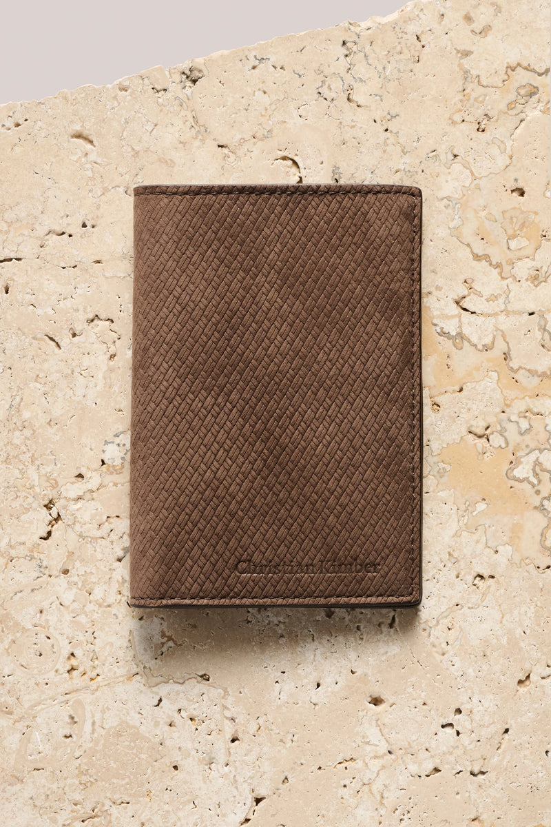 Christian Kimber Nubuck Leather Jacket Wallet in chocolate, closed, flat lay on travertine stone