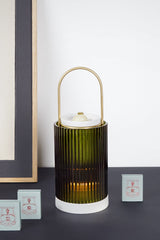 Trudon La Promeneuse Coffret, lit lantern on a dark shelf with boxes of cameos and night lights