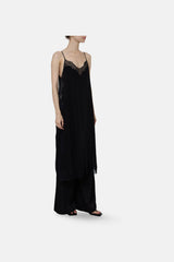 Black Balma silk slip dress worn over wide black trousers, front view