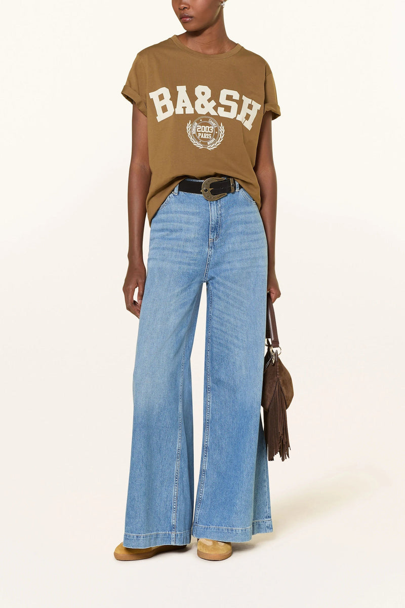 Caramel brown tee with a cream BA&SH varsity print, worn with wide light jeans and a brown suede bag