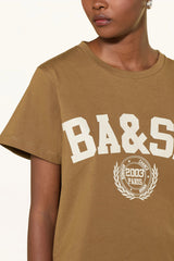Close view of the cream BA&SH 2003 Paris crest on the caramel brown tee