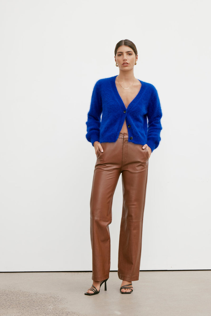 Cecilia cropped cardigan in cobalt, buttoned and worn with tan leather trousers, full length