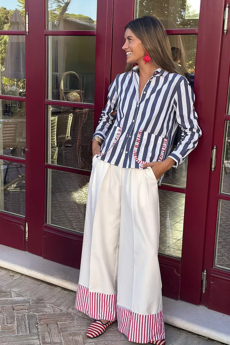 Volantitos navy and white stripe shirt with red-trimmed pockets, worn with white wide-leg trousers